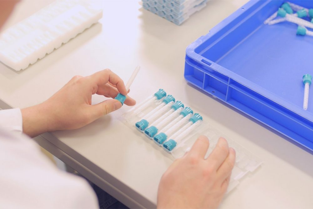 zwei Hände sortieren sorgfälltig Kanülen in eine durchsichtige Verpackung