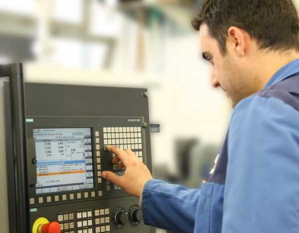 Ein Mann programmiert eine CNC-Maschine