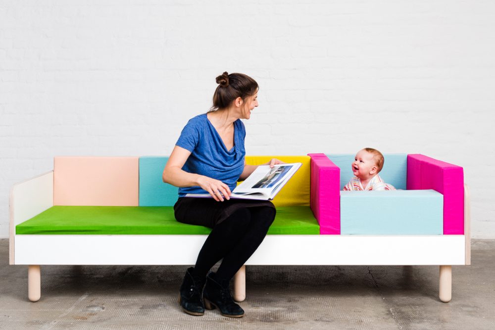 Eine Mutter lächelt ihr Baby an während beide auf dem growing bed sitzen