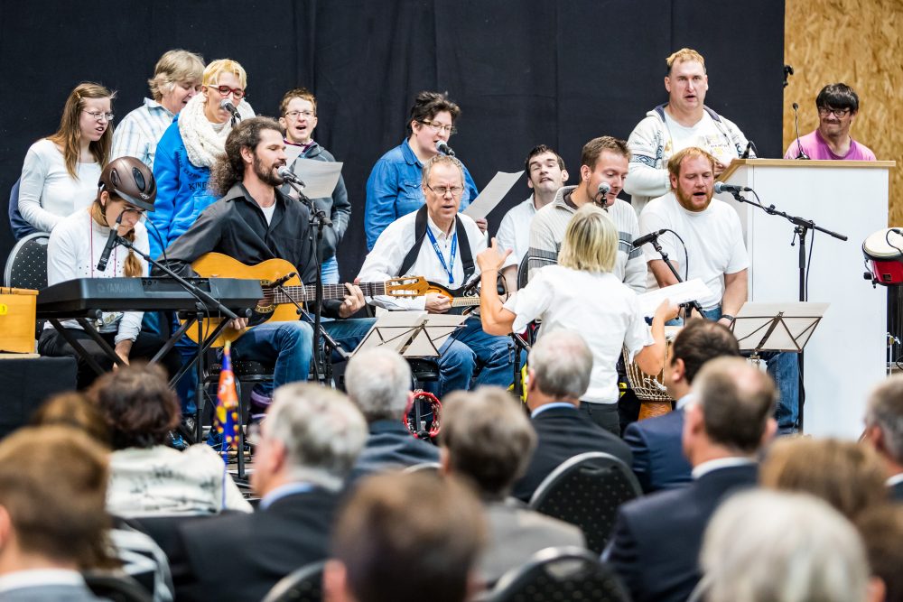 Menschen musizieren miteinander auf einer Bühne