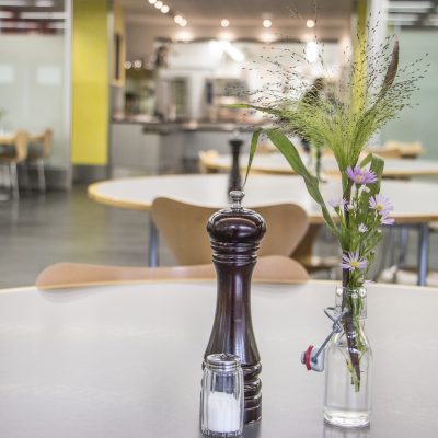 Blick in die Kantine der Pfennigparade von einem Tisch mit Salz und Pfferstreuer